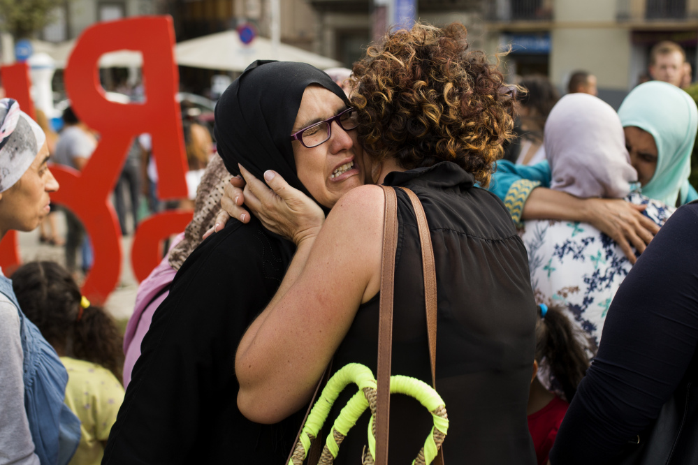 Families of young men believed responsible for the attacks in Barcelona and Cambrils gather along with members of the local Muslim community to denounce terrorism in Ripoll, Spain, on Saturday.