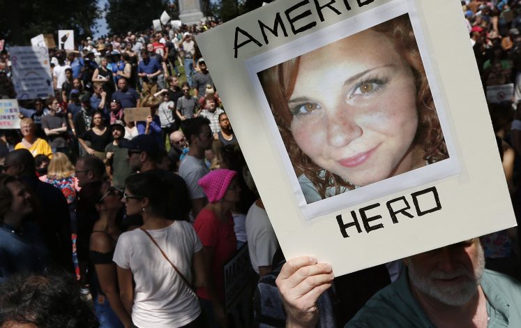 A counterprotester on Boston Common Saturday holds a photo of Heather Heyer, who was killed Aug. 12 in Charlottesville, Virginia, when an alleged Nazi sympathizer rammed a crowd of anti-racist protesters.