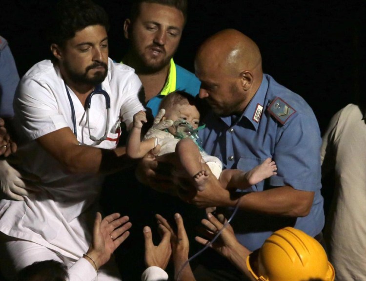Rescuers pull out 7-month boy Pasquale from the rubble of a collapsed building in Casamicciola, on the island of Ischia, near Naples, Italy, on Tuesday.