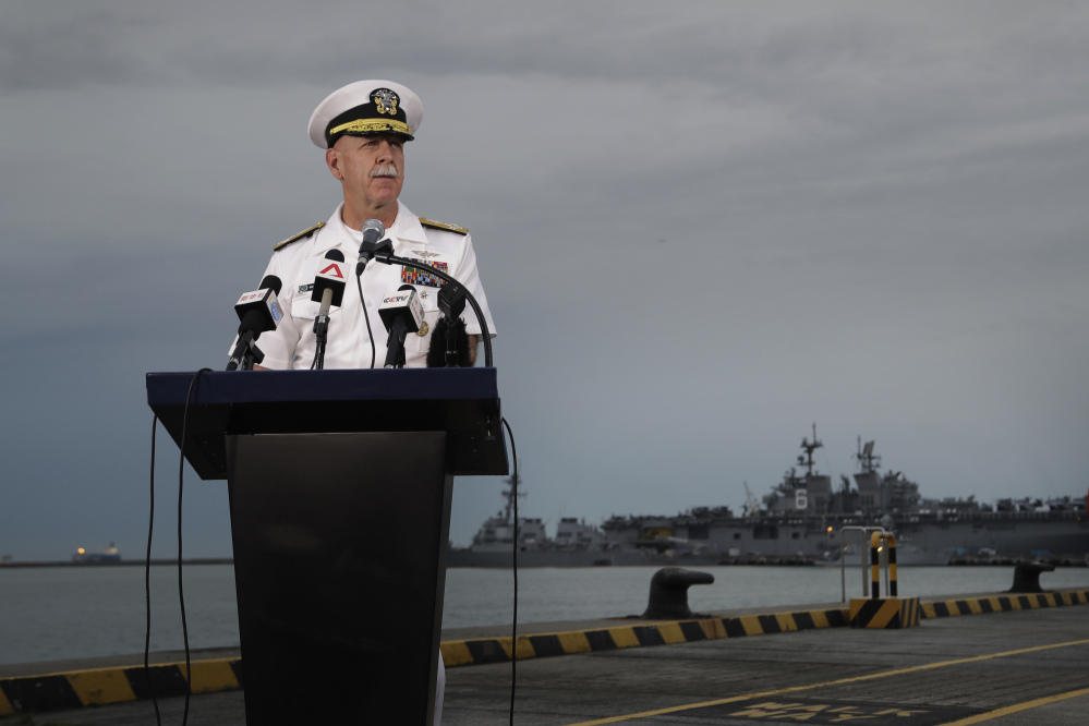 Adm. Scott Swift, commander of the U.S. Pacific Fleet, answers questions at a press conference Tuesday with the USS John S. McCain and USS America docked in the background at Singapore's Changi naval base. Responding to Monday's fatal accident involving the McCain, he said, "One tragedy like this is one too many."