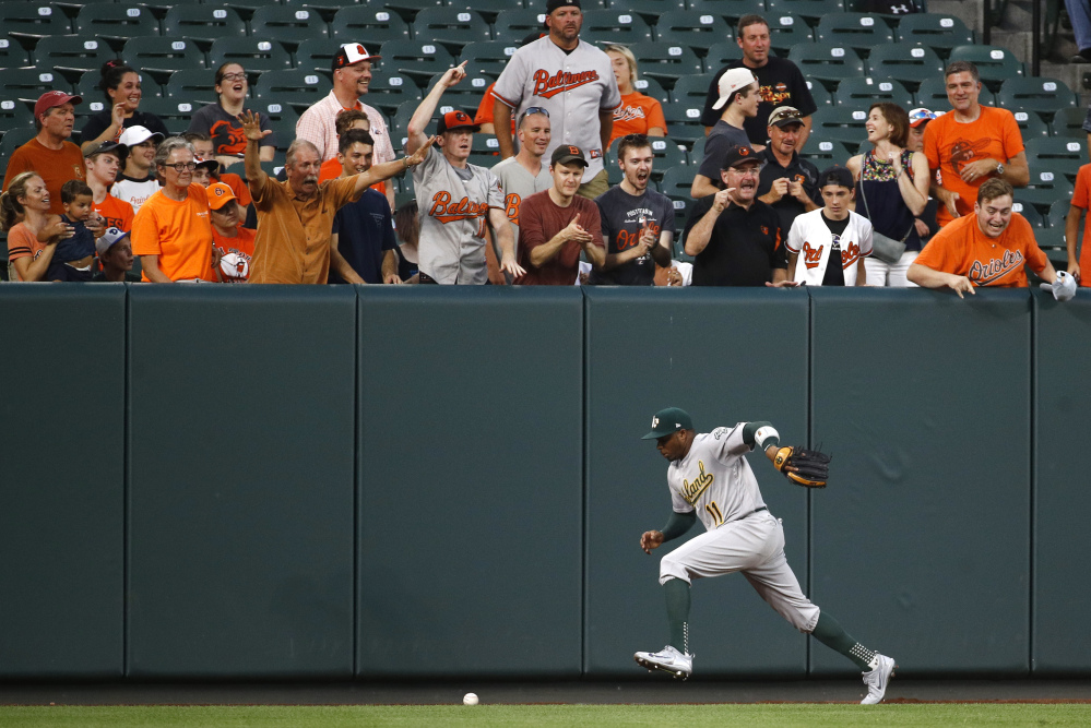 Oakland Athletics left fielder Rajai Davis chases after a fly ball single that hit by Baltimore Orioles' Chris Davis in the second inning Monday.