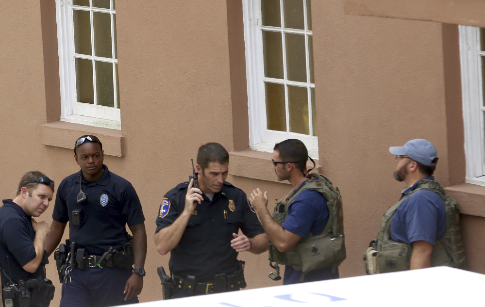 Police gather near the scene of a shooting in Charleston, S.C., on Thursday. Authorities say a disgruntled employee shot one person and was holding hostages in a restaurant in an area that is popular with tourists. The gunman was later shot by police.