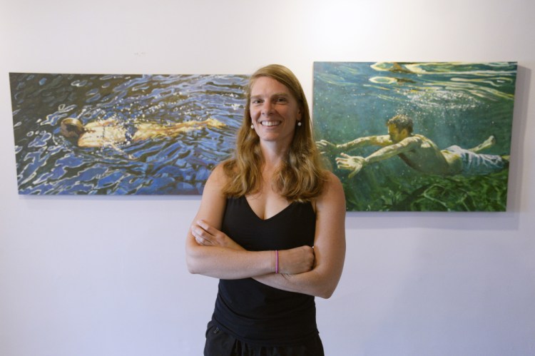 Jessica Lee Ives in her Camden studio with two of her paintings, "Watermark," left, and "Become Alive."