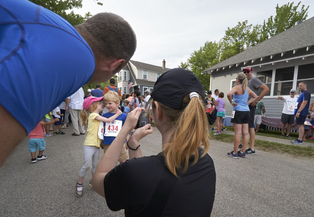  Ariane Vinet, 3, turns to her brother Alexis, 5, while their mother Catherine Awad takes their photo and their father Dominic Vinet watches before the start of the Kids Fun Run in Ocean Park. The family is from Montreal  and were vacationing in Ocean Park. 