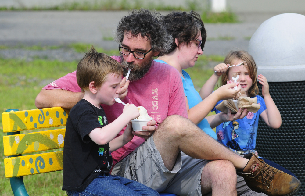 From left, Sebastian, David, Kendra and Eve Hughes eat ice cream Tuesday at a Manchester playground. Autistic kids need structure in summer for a good transition to school in the fall.