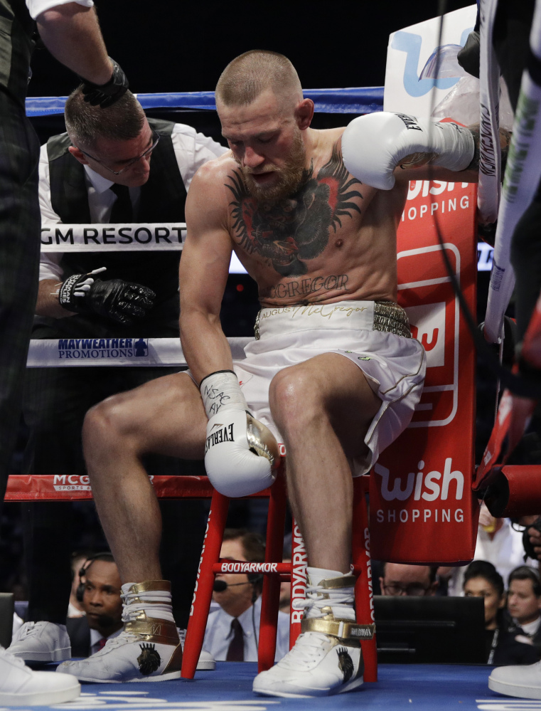 Conor McGregor sits in his corner between rounds of his super welterweight boxing match against Floyd Mayweather Jr.