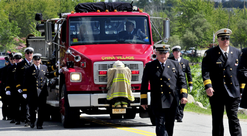 Former Fire Chief George Studley's helmet, boots and fire coat are mounted on a China Village firetruck Sunday for a procession of fire departments that made their way to the station for a last call ritual for Studley, who died Aug. 18.