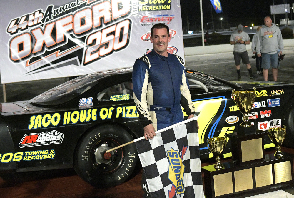 Curtis Gerry of Waterboro holds the checkered flag after winning the Oxford 250 on Sunday at Oxford Plains Speedway.
Staff photo by Andy Molloy