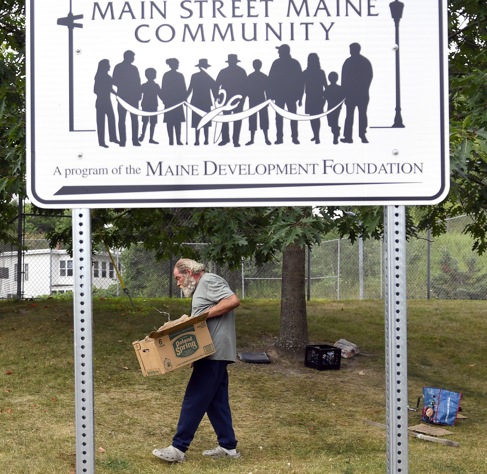Paul Merrick, 55, carries belongings after Augusta police told him to leave his campsite off of Mount Vernon Avenue. Merrick has as many as eight spots in the city where he camps. Staff photo by Andy Molloy