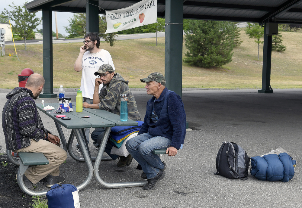 A group of homeless men discuss where to set up camp in Augusta. There's nothing prohibiting them from spending time on public property during the day, but camping out at night isn't allowed. Shelters are an option but fill up quickly. Staff photo by Andy Molloy
