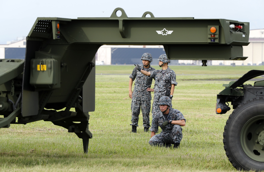 Japanese Air Self-Defense Force members demonstrate the training to use the PAC-3 surface-to-air interceptors at the U.S. Yokota Air Base in Fussa, on the outskirts of Tokyo, on Tuesday. The pre-planned training took place the same morning North Korea fired a missile over Japan.