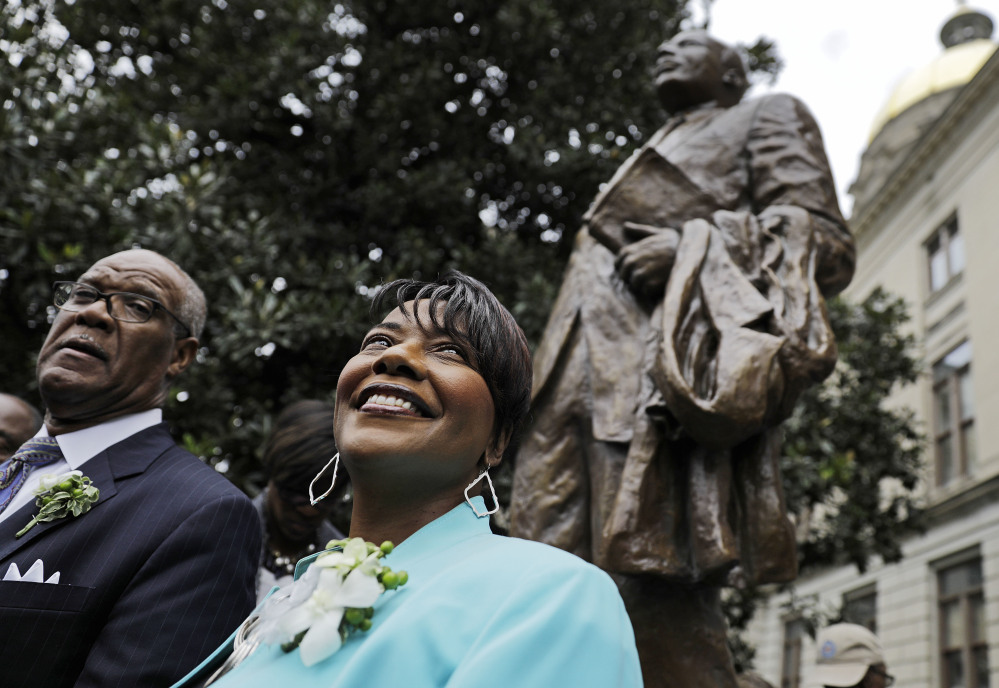 The Rev. Bernice King, daughter of the Rev. Martin Luther King Jr., stands under a statue paying tribute to her father after its unveiling on the Capitol grounds Monday in Atlanta.