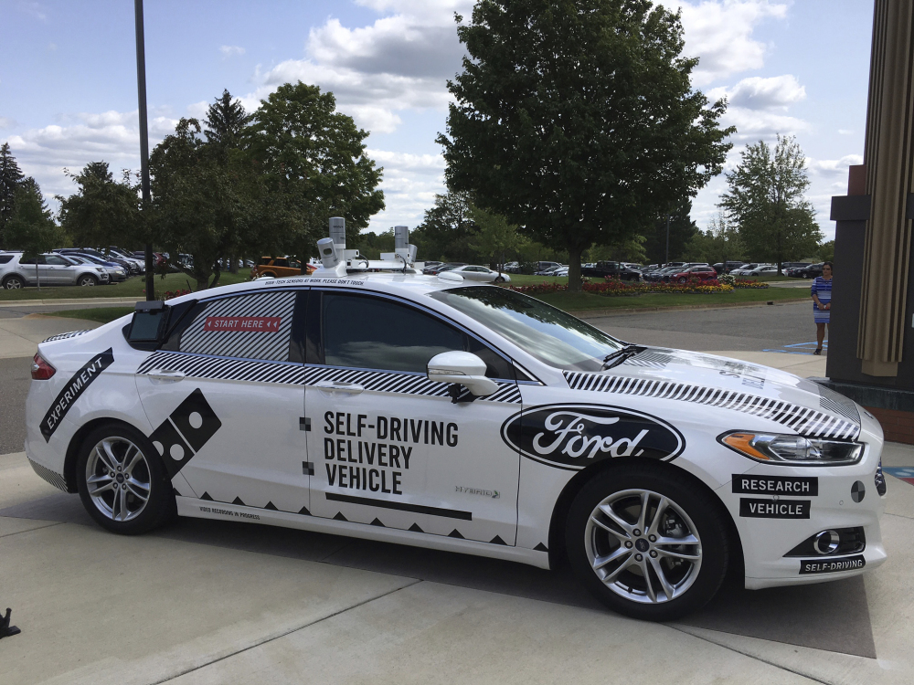 This Friday, Aug. 24, photo, shows the specially designed delivery car that Ford Motor Co. and Domino's Pizza will use to test self-driving pizza deliveries, at Domino's headquarters in Ann Arbor, Mich. Ford and Domino's are teaming up to test how consumers react if a driverless car delivers their pizzas. The car, which can drive itself but will have a backup driver, lets customers tap in a code and retrieve their pizza from a warming space in the back seat.