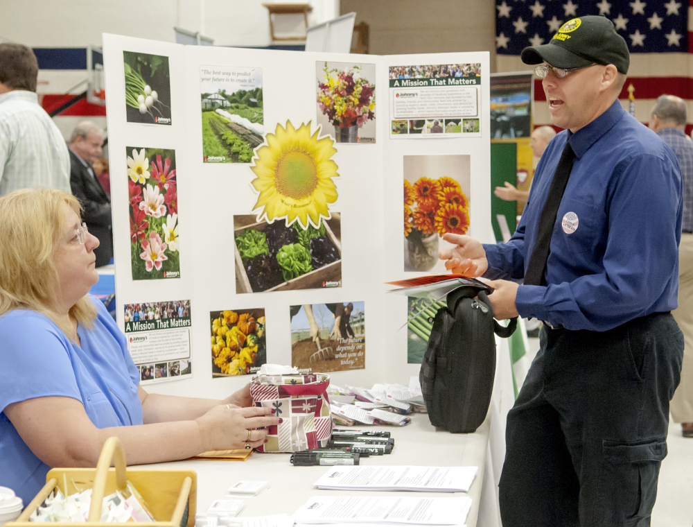 Cheryl Doucette, of Johnny's Selected Seeds, left, and Army veteran Franklin Smart, chat during job fair Tuesday at the Augusta Armory.