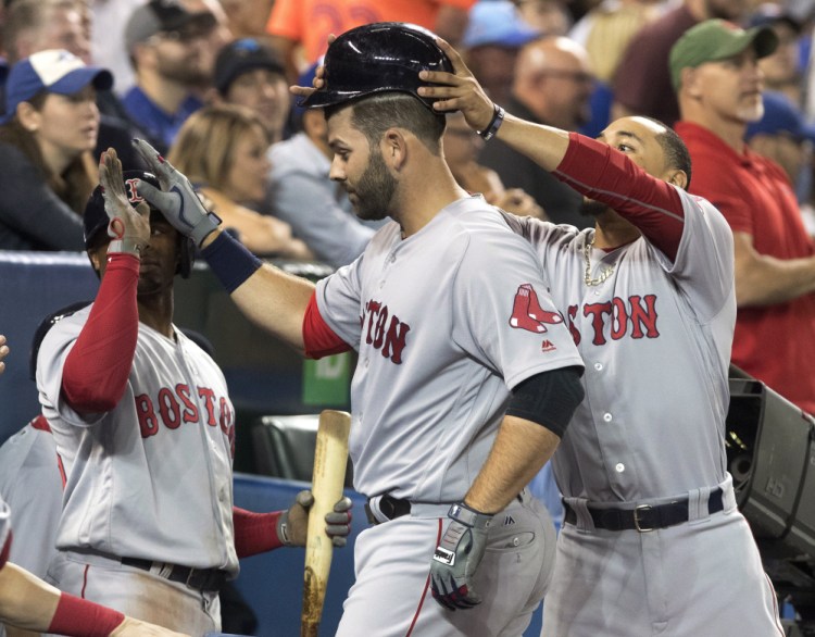 Boston's Mitch Moreland is congratulated after hitting a two-run home run against the Blue Jays in the seventh inning Wednesday night in Toronto.