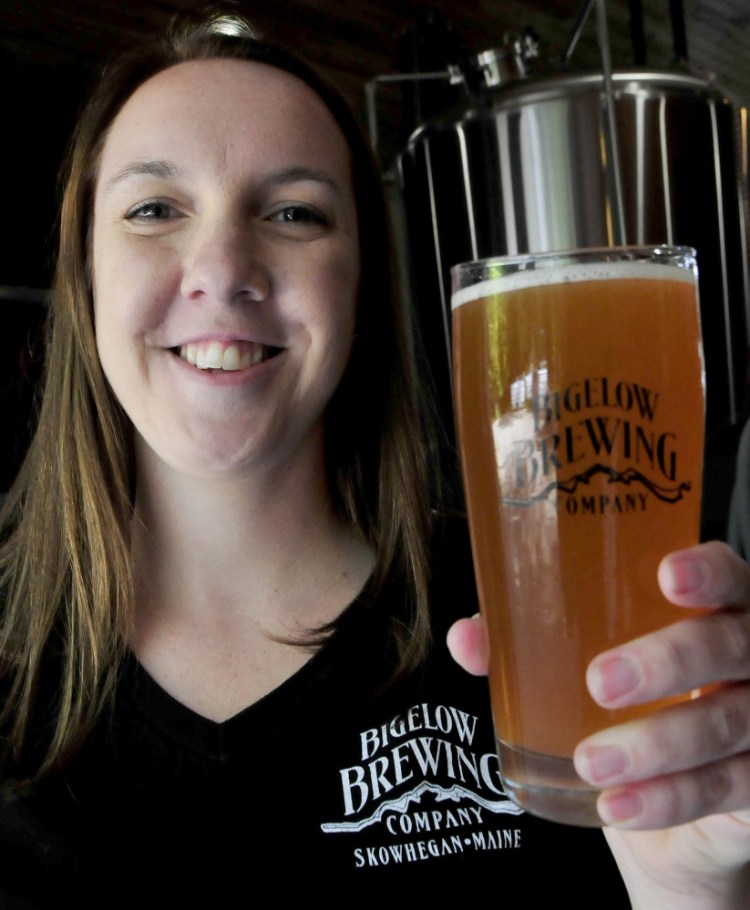 Bigelow Brewing Co. employee Jordan Powers shows off La Saison du Labrador beer, a collaboration of Bigelow and a Quebec brewery, that was brewed for Saturday's festival.