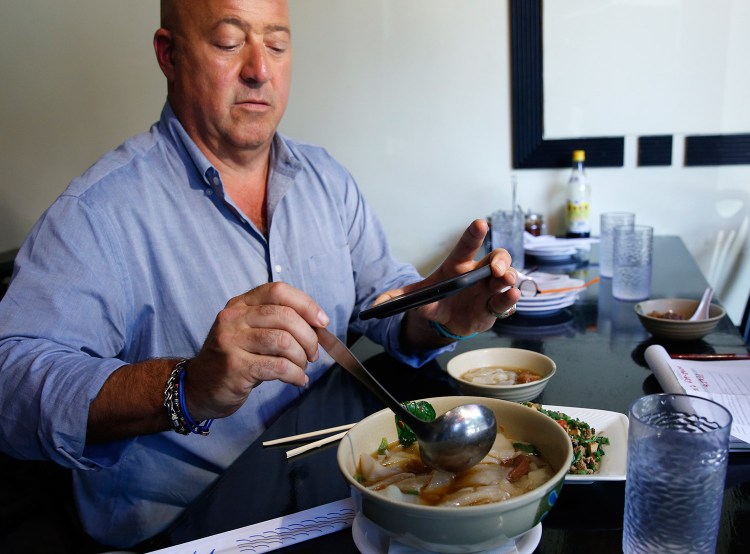A Maine spice company is developing seven special spice blends for food TV personality Andrew Zimmern’s online store, all based on Zimmern’s recent travels. He is shown here in July taking a photo of his Taiwanese noodle soup.