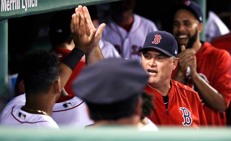 Manager John Farrell congratulates third baseman Rafael Devers, whose alert defense started a triple play Tuesday night for the Boston Red Sox against the St. Louis Cardinals.