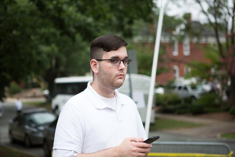 James Alex Fields Jr. stands on the sidewalk looking at the procession of clergy as they gathered at McGaffey park prior to a rally in Charlottesville, Virginia, on Aug. 12. Fields is accused of ramming his car into a crowd of counter-protesters, killing 32-year-old Heather Heyer and injuring over a dozen others. 