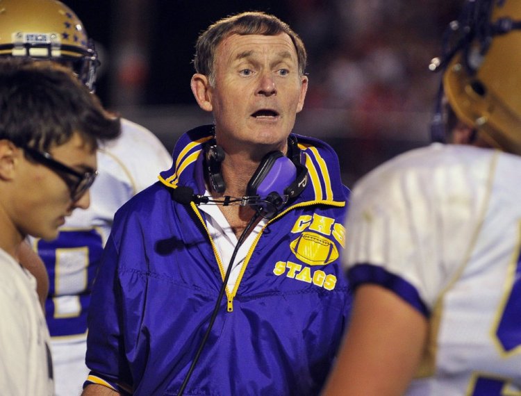 John Wolfgram, shown speaking with Cheverus football players during a 2010 game, is returning to the school as defensive coordinator. Wolfgram retired last year after 40 years as a head coach in Maine.