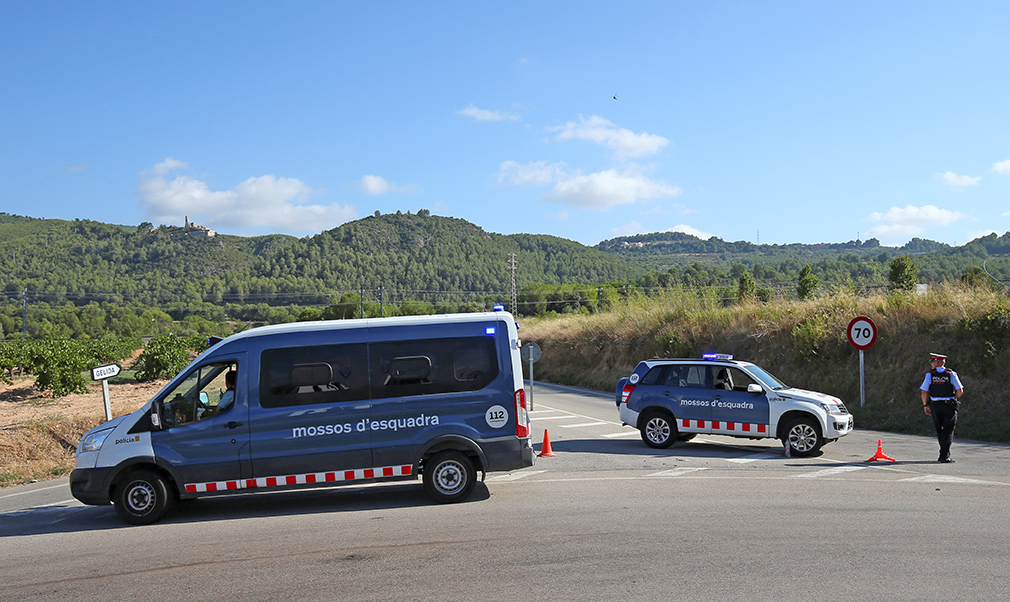 Catalan Mossos d'Escuadra officers and vans block a road near the place where a suspect was killed by police in Sant Sadurni d'Noia on Monday.