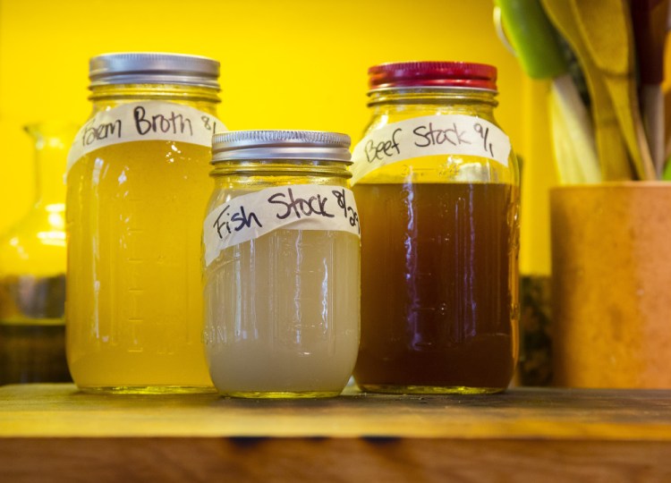 Broth stocks are in labeled jars on the kitchen counter. 
