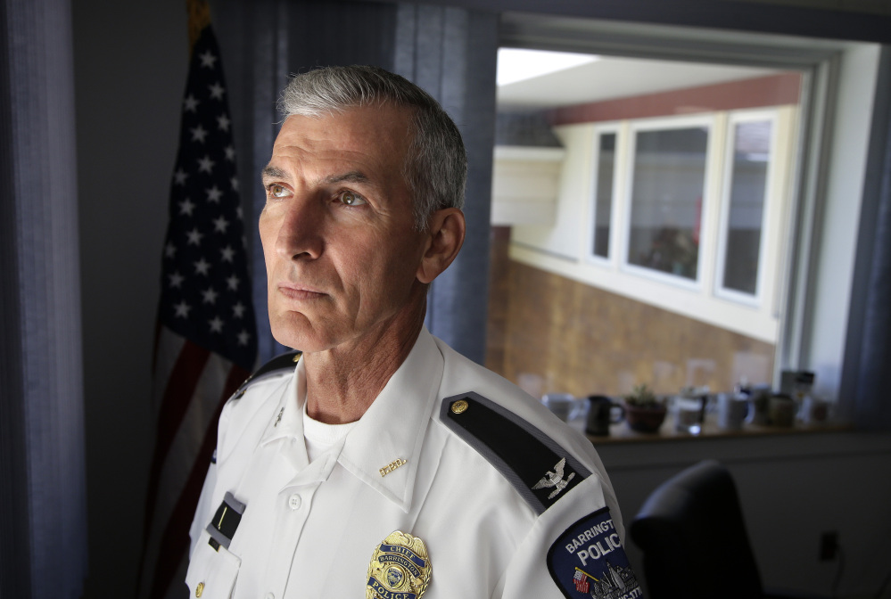 Barrington, R.I., Police Chief John LaCross stands for a photograph in his office. LaCross, who lost his brother to suicide in 1979, believes there is a growing trend of people turning to psychics after losing a loved one.