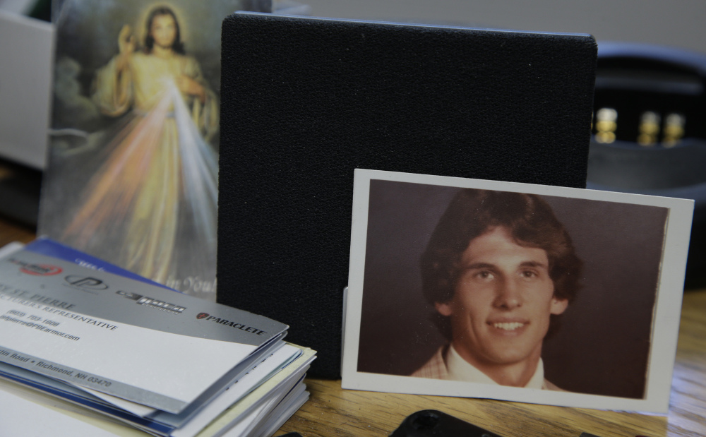 A photograph of Joseph LaCross rests near an image of Jesus on the desk of Barrington, R.I., Police Chief John LaCross at the police station in Barrington.