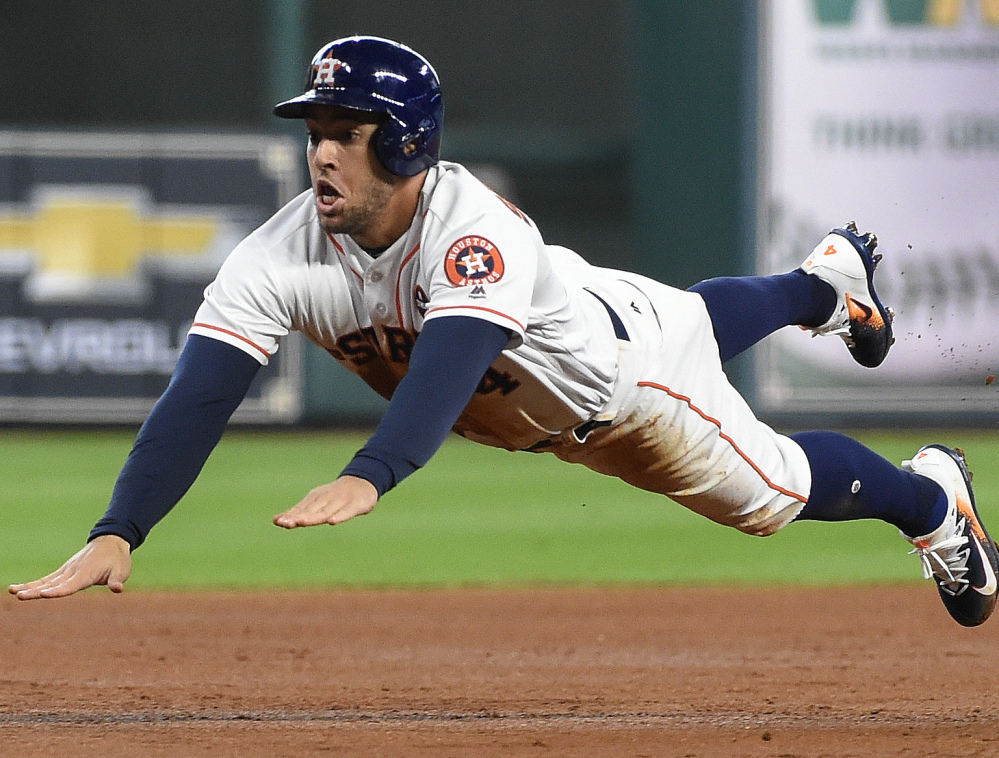 Houston's George Springer slides safely into third on Alex Bregman's single during the Astros' 12-8 win in Game 1 of a doubleheader against New York on Saturday.