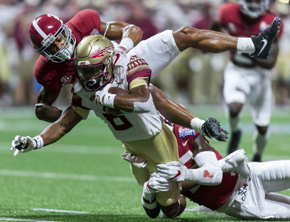 Alabama defensive backs Anthony Averett, top, and Shyheim Carter (5) stop Florida State wide receiver Nyqwan Murray.