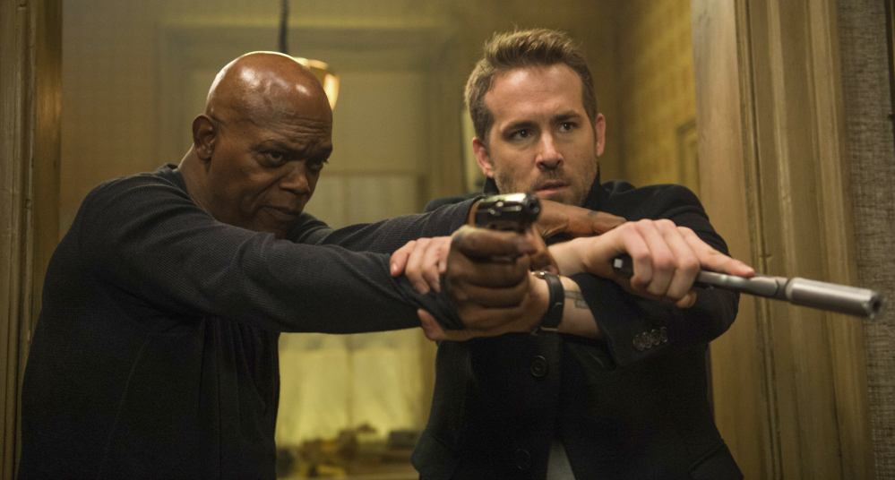 Samuel L. Jackson, left, and Ryan Reynolds appear in "The Hitman's Bodyguard," which topped the box office charts for the third weekend in a row. (Jack English/Lionsgate via AP)
