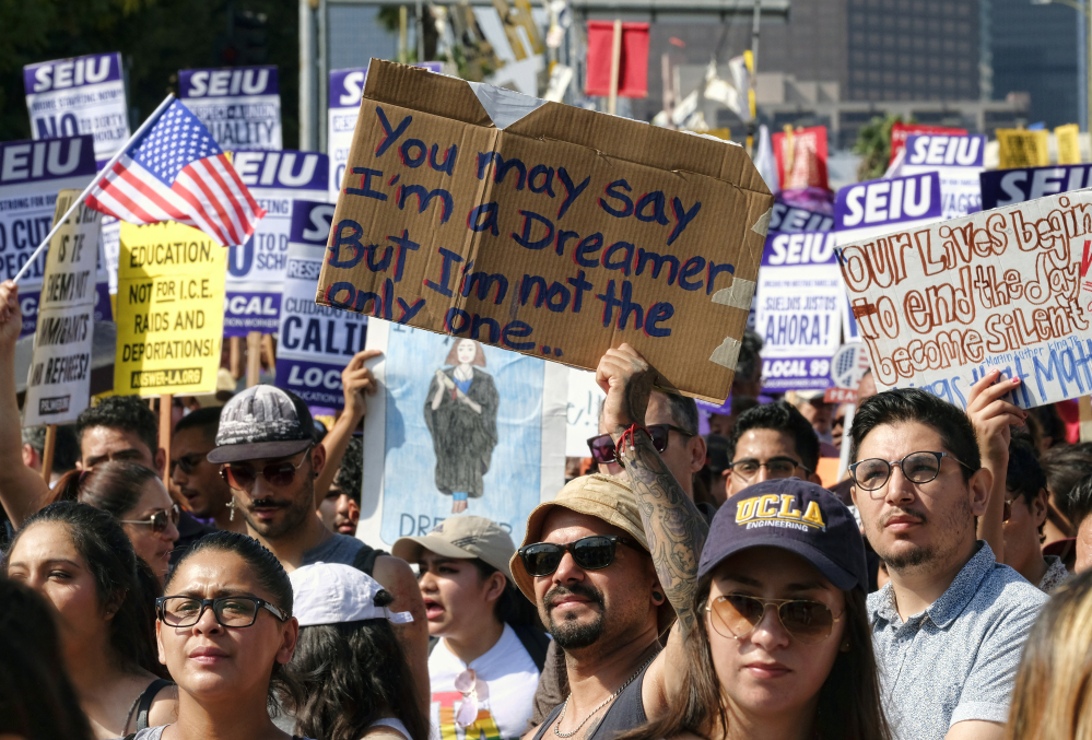 Above and below, young and older supporters of the Deferred Action for Childhood Arrivals, or DACA, program chant slogans and hold signs while joining a Labor Day rally Monday in downtown Los Angeles.