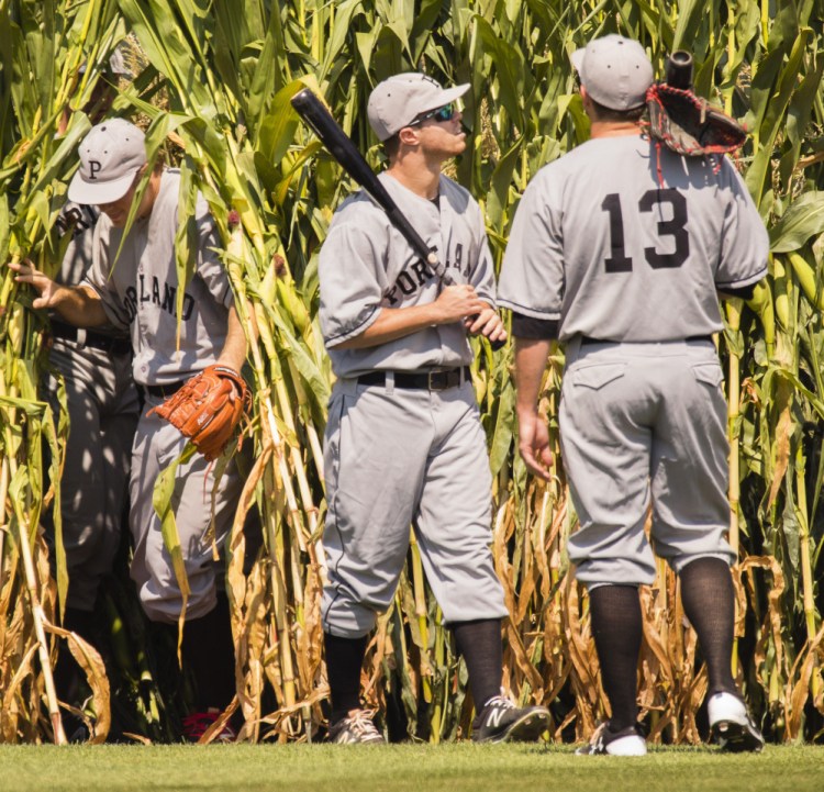 It's not heaven, or Iowa, but Hadlock Field that Portland Sea Dogs players Ty Buttrey, left, Mike Myers and Danny Bethea emerge onto from the cornfield in center field for the team's annual Field of Dreams game on Monday.