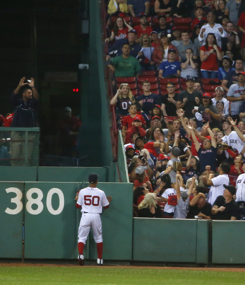 Mookie Betts watches a three-run home run ball hit by the Blue Jays' Kendrys Morales in the first inning.