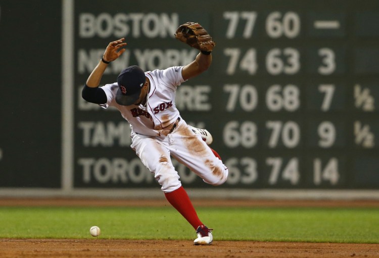 Red Sox shortstop Xander Bogaerts loses the ball while trying to force out a runner at second base in the second inning of Monday night's game – and ugly game for Boston.