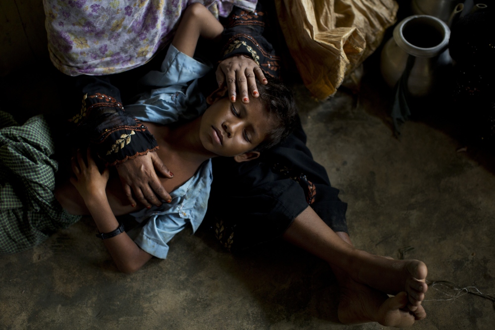 A Rohingya woman comforts her exhausted son as they take shelter at a refugee camp in Bangladesh after having just arrived from the Myanmar side of the border Thursday.