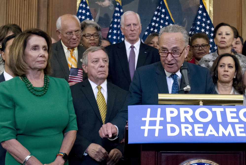 Senate Minority Leader Chuck Schumer of New York and House Minority Leader Nancy Pelosi of California appear with Democrats on Wednesday in Washington. President Trump's alliance with Democrats has Republicans baffled.