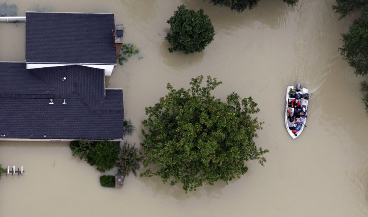 Residents evacuate their homes near the Addicks Reservoir as floodwaters from Tropical Storm Harvey rise in Houston on Aug. 29. Heavily subsidized federal flood insurance has tilted migration toward vulnerable coastal regions of the Sunbelt.