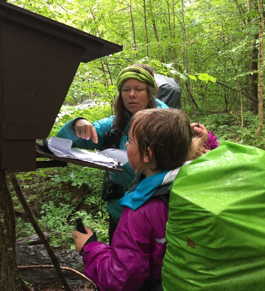 Yarrow Upton and her daughter, Zella, 9, sign a trail register Sunday at the close of their thru-hike of the Long Trail in Vermont, the oldest long-distance trail in the United States.