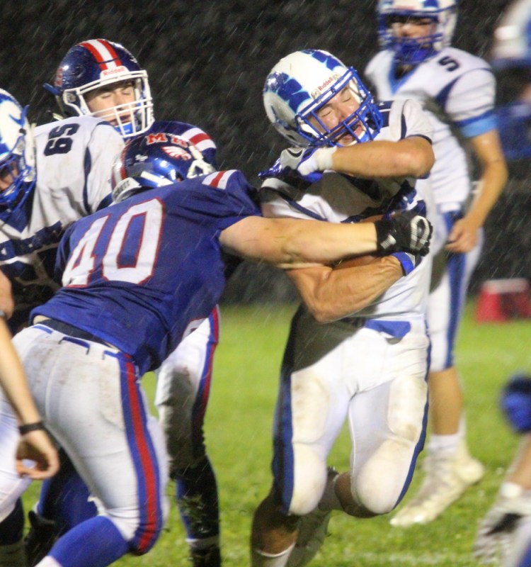 Messalonskee defender Colton Chavarie tries to strip the ball from Kennebunk's Jake Littlefield during the first half of their Class B game Friday night in Oakland. Kennebunk won, 32-7.