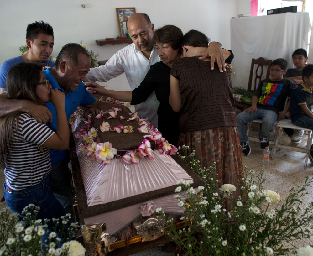 Family members grieve over the coffin containing the remains of 64-year-old Reynalda Matus Martinez during a wake in Juchitan, Oaxaca state, Mexico, on Saturday.