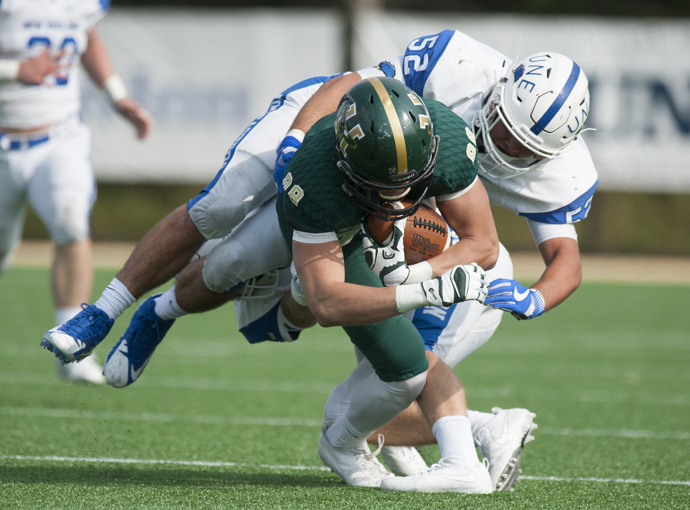 University of New England linebacker Nick Scarfo brings down Patrick Cullen during Sunday's game against Husson University's JV team in Bangor. UNE, which is playing JV and prep school opponents this fall before moving to varsity status in 2018, lost 34-21.