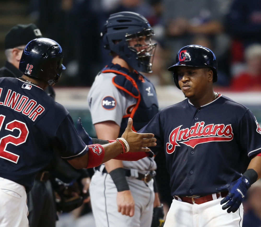 Cleveland's Jose Ramirez gets congratulations from Francisco Lindor, left, after hitting a two-run home run off Detroit starting pitcher Myles Jaye as catcher James McCann stands in the background during the Indians' 11-0 win Monday in Cleveland.