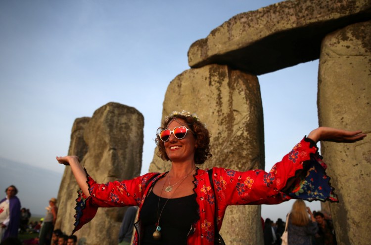 A woman watches the sunrise at Stonehenge on the summer solstice, June 21, near Amesbury, Britain.