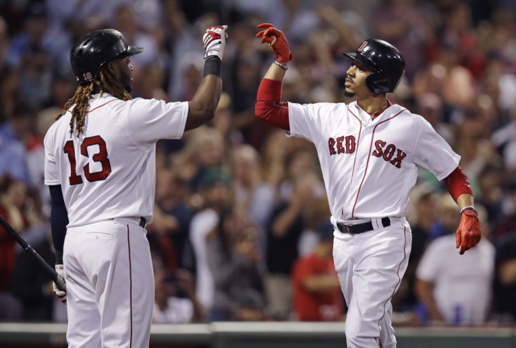 Boston’s Mookie Betts, right, is congratulated by Hanley Ramirez after his two-run homer during the fourth inning of Tuesday night’s rout of the Oakland Athletics at Fenway Park.