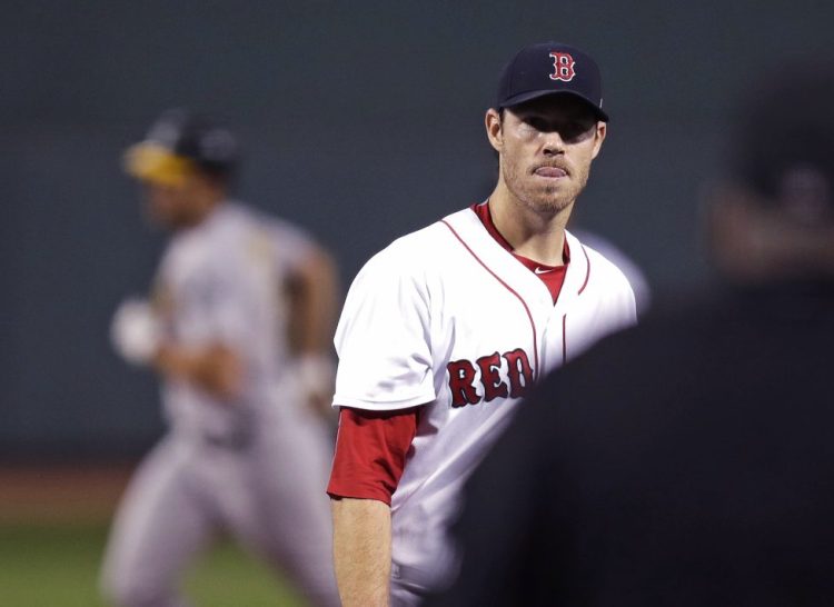Red Sox starter Doug Fister waits for a fresh baseball as Oakland's Matt Olson rounds the bases after hitting a two-run home run in the first inning at Fenway Park Wednesday night.