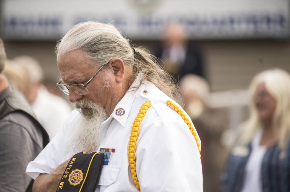 American Legion member Bill O'Neil lowers his head during a prayer Friday at the memorial groundbreaking at the Legion's Maine headquarters in Winslow.