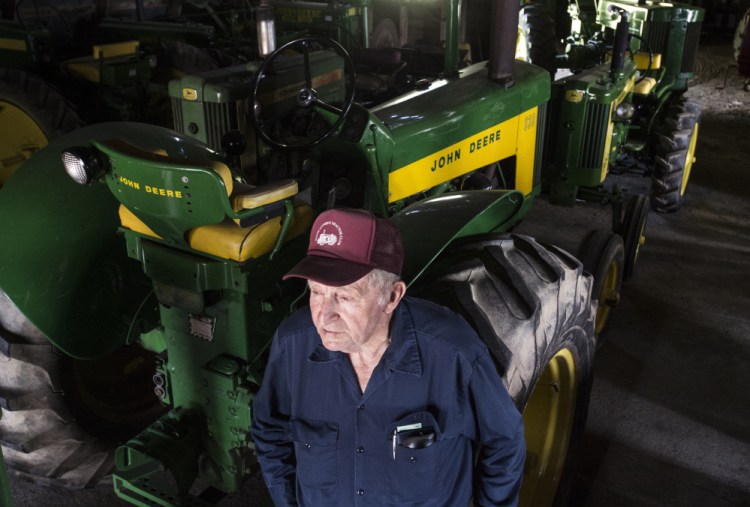 Bill Clark, a charter member of the Maine Antique Tractor Club, stands with his nearly 40 John Deere tractors Thursday in his Skowhegan barn.