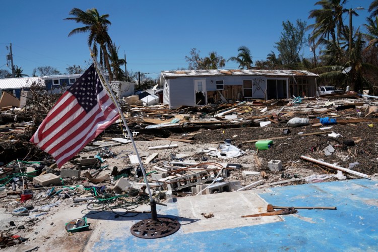 A flag flies over a debris field of destroyed houses following Hurricane Irma in Islamorada, Fla., on Friday. Returning residents of the Keys were told electricity, sewer and water were "intermittent at best." Curfews are in effect and schools are still closed until at least Sept. 28.