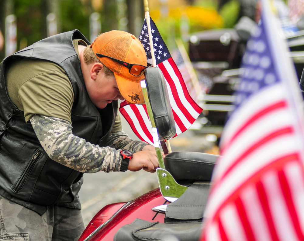 Coleby Monteith, 11, of Randolph, attaches an American flag to his grandfather's motorcycle Saturday before they rode in the 2017 Maine Fallen Heroes Bike Run at the Maine Veterans' Home in Augusta.